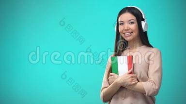 女孩听意大利<strong>耳麦</strong>音频课程，手里拿书，翻译